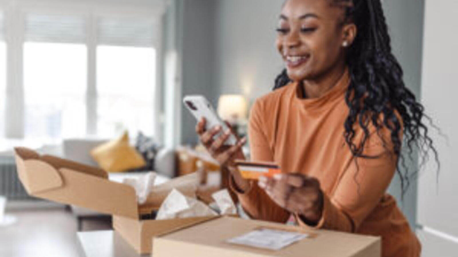 Woman on phone with credit card in hand